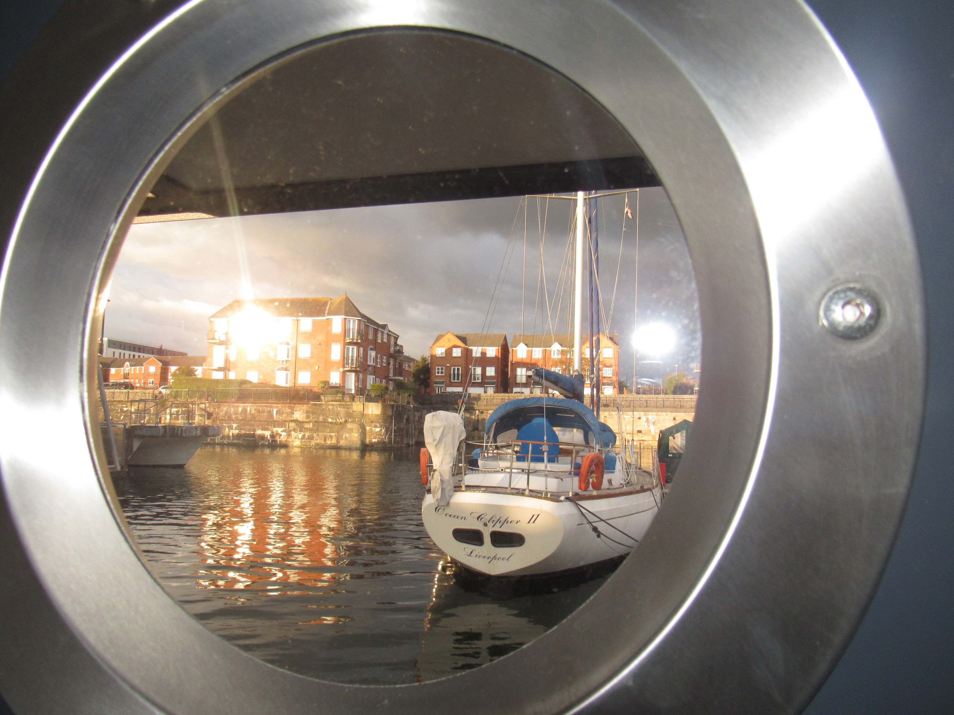 View through the houseboat porthole of sailboat Ocean Clipper II at golden hour